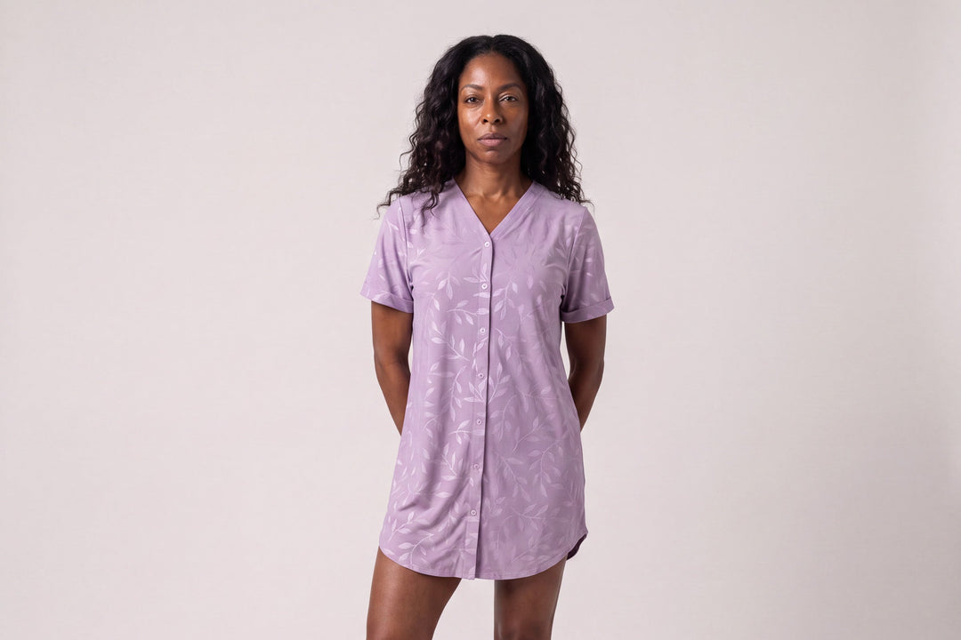 Woman standing in a violet leaf print NightCool snap front nightshirt that opens all the way down the front
