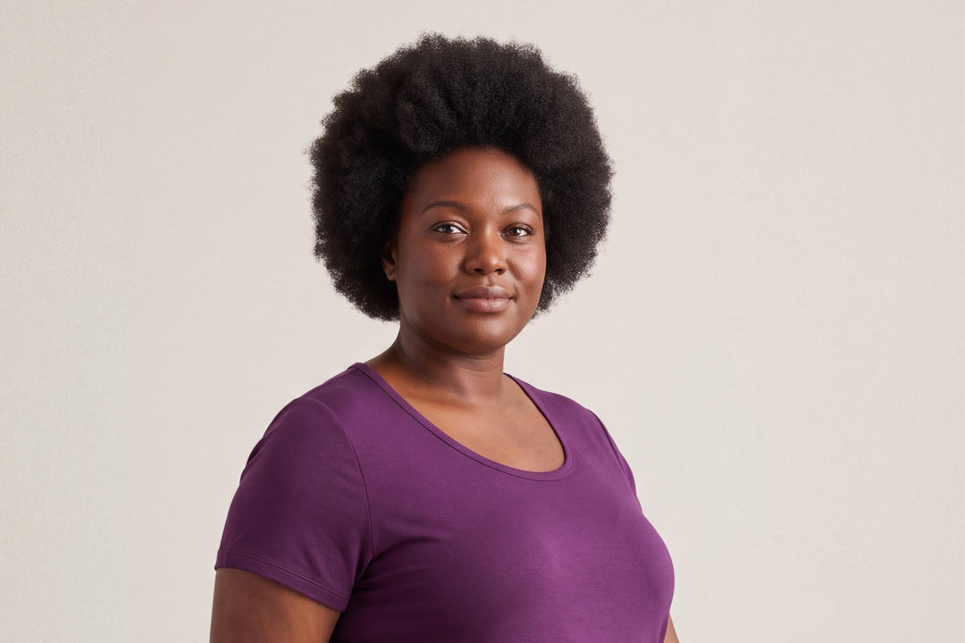 Woman in a merlot NightCool scoop t-shirt standing against a warm greige studio backdrop